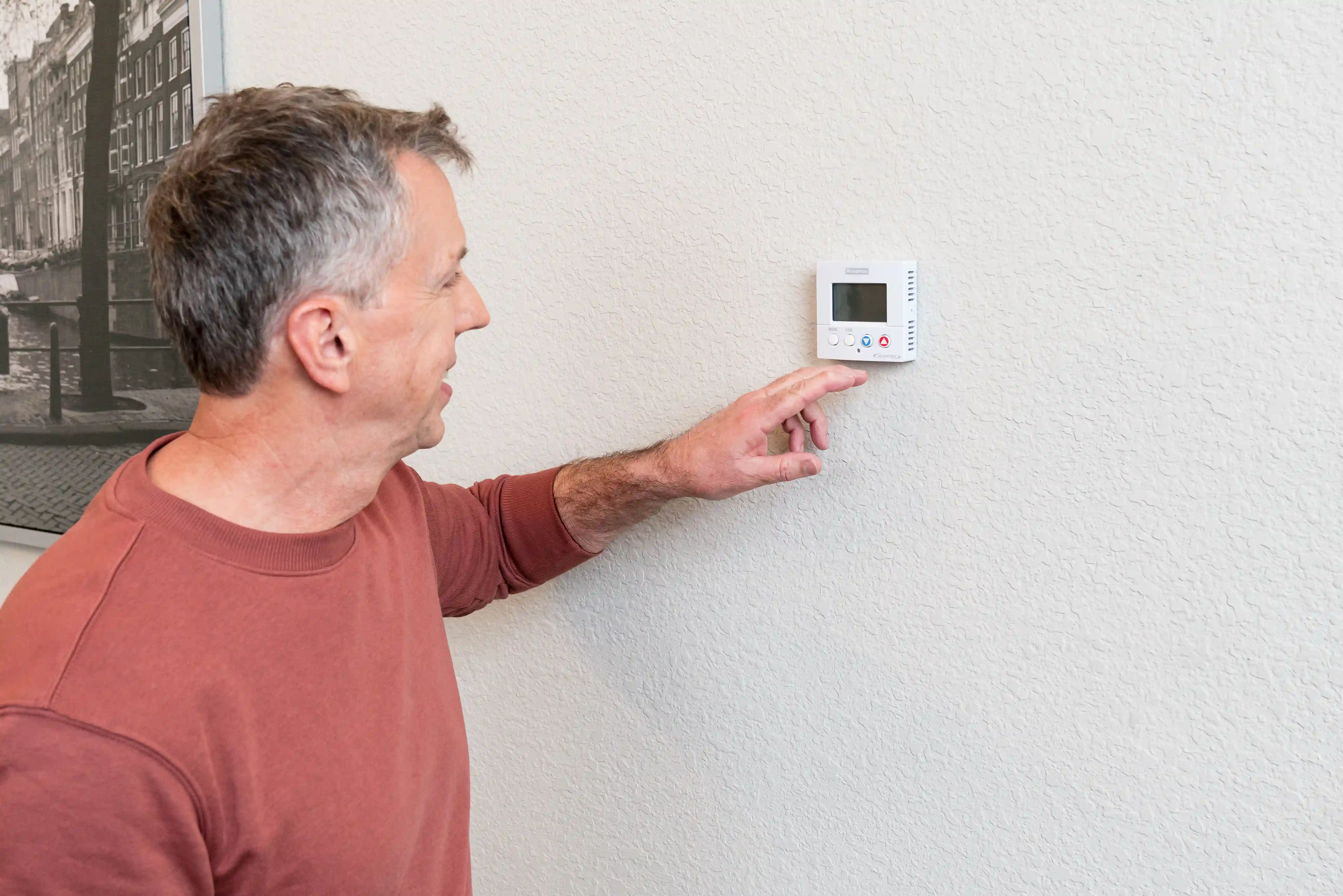 Homeowner adjusting thermostat for ideal comfort